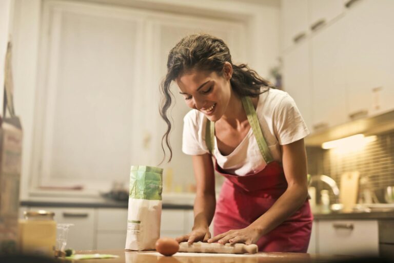 happy woman with rolling pin cooking at home