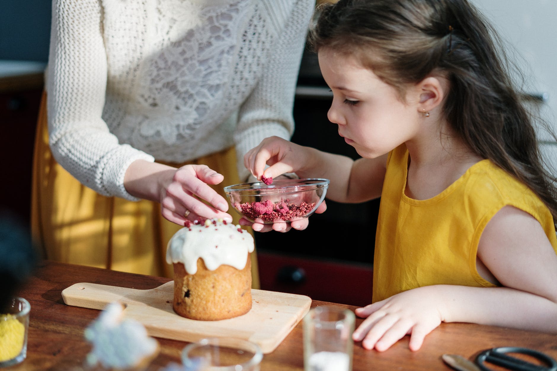 girl in yellow shirt holding brown cake