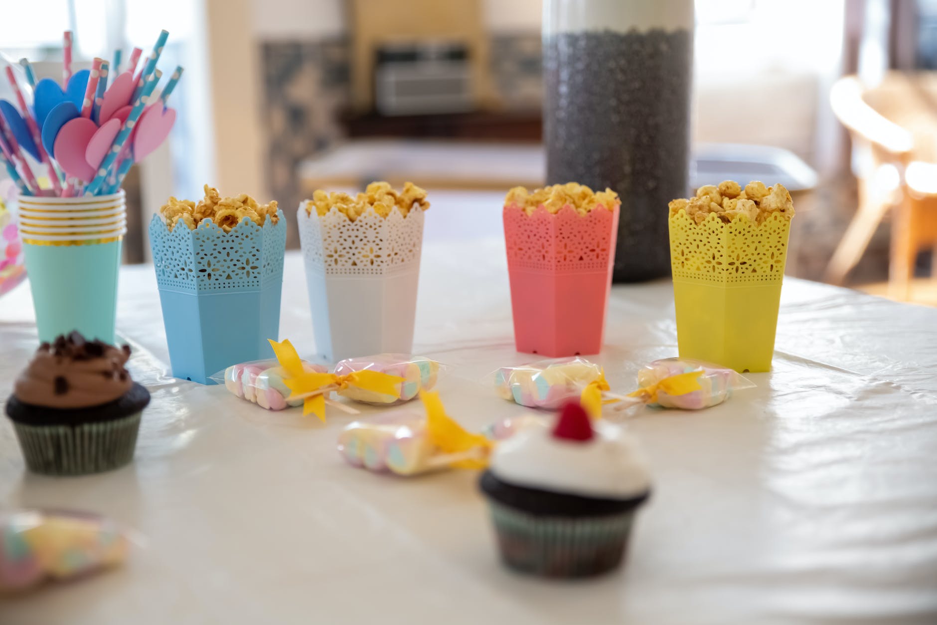 containers filled with popcorn and cupcakes standing on the table