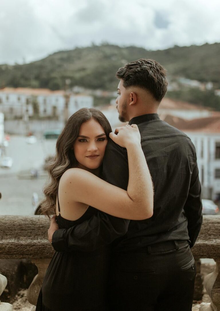 couple hugging near handrail in port