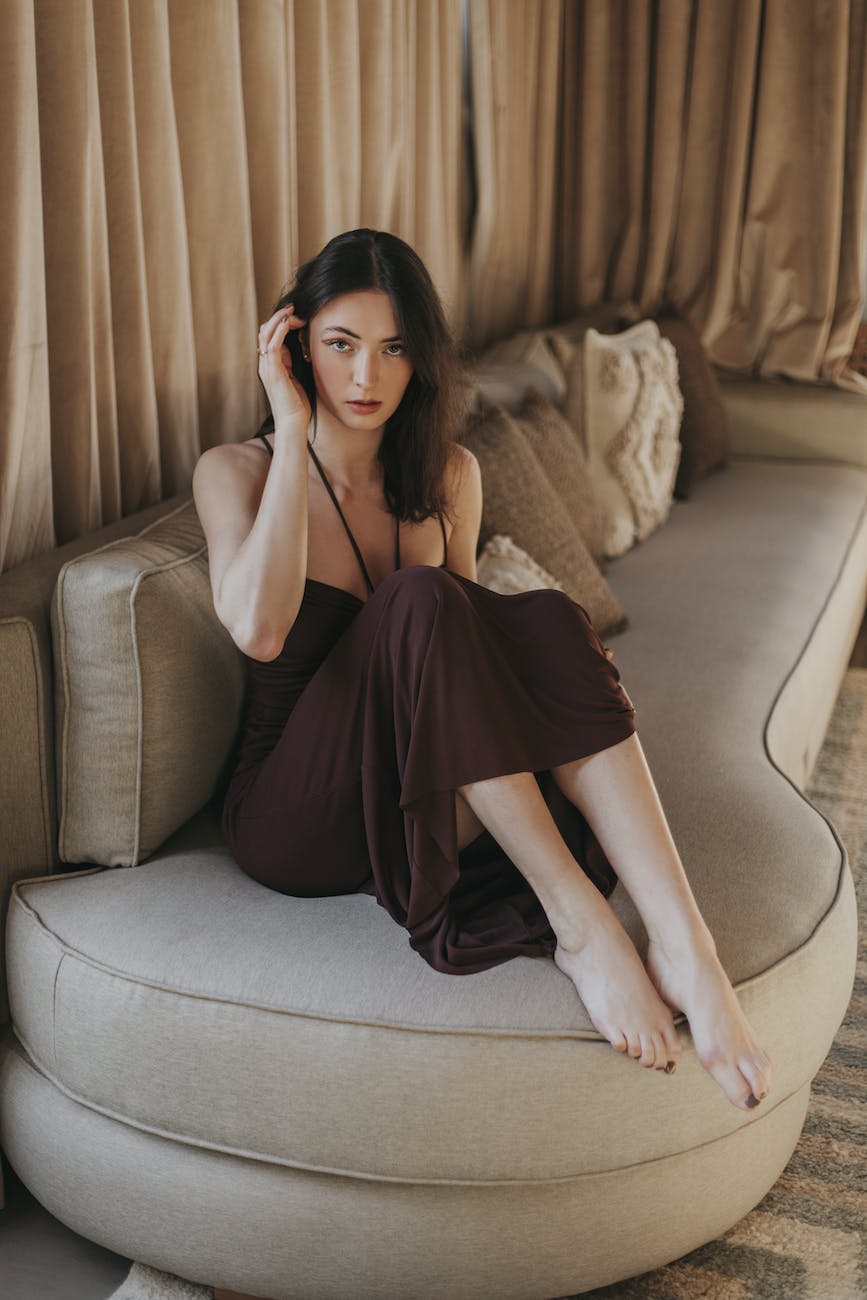 woman in dress sitting on couch