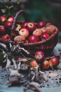 wicker basket with ripe apples and walnuts